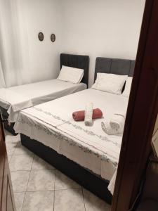 two beds in a room with towels on them at Anna's Garden House in Limenas