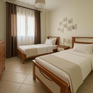 a hotel room with two beds and a window at Gony's Apartment in Orfánion