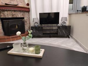 a living room with a television and a table with a tray with flowers at Anna's Garden House in Limenas