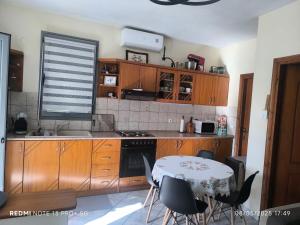 a kitchen with wooden cabinets and a table with chairs at Anna's Garden House in Limenas