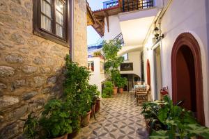a hallway of a building with potted plants at Achilleas Pension in Hydra