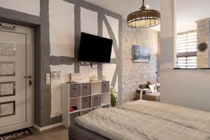 una camera da letto con un letto e una TV a parete di Unterkunft Alte Schlosserei a Mühlhausen