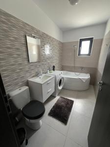 a bathroom with a toilet and a sink and a tub at Dobroesti Relax Apart in Dobroeşti