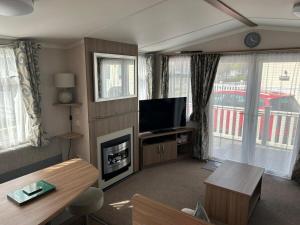 a living room with a fireplace and a television at Molly's Haven in Milford on Sea