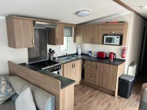 a small kitchen with wooden cabinets and a microwave at Molly's Haven in Milford on Sea