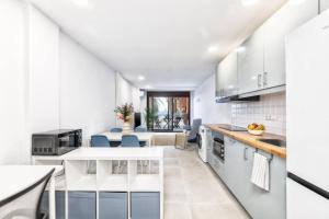 cocina con armarios blancos y comedor en Ocean Blue Dream, en Breña Baja