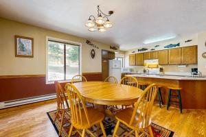 a kitchen and dining room with a wooden table and chairs at Aspen Village Golf Course Condo - Snowshoes in McCall