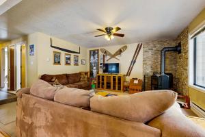 a living room with a couch and a ceiling fan at Aspen Village Golf Course Condo - Snowshoes in McCall