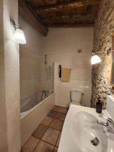 a bathroom with a tub and a sink and a toilet at Le Clos Sainte Marie - Caune in Cenne-Monestiès