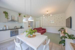 a kitchen and living room with a white table and chairs at Appartamenti Villa Andrea in Garda