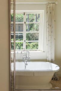 una bañera en un baño con ventana en Buccara Noetzie - Honeymoon Castle, en Knysna