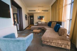 a living room with two couches and a tv at Holiday Inn Abu Dhabi by IHG in Abu Dhabi