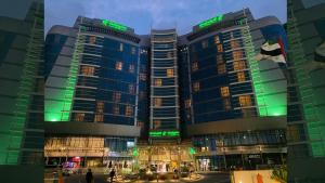 a group of tall buildings in a city at night at Holiday Inn Abu Dhabi by IHG in Abu Dhabi