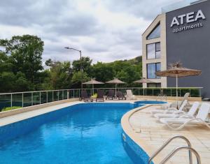 a pool at a hotel with chairs and umbrellas at ATEA PERLA apartments in Kavarna