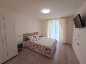 a bedroom with a bed and a television and a window at ATEA PERLA apartments in Kavarna +9 photos
