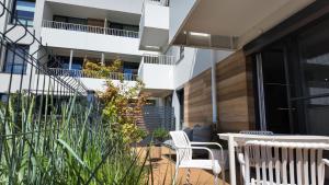 a patio with chairs and a table and a building at Zakątek Kwiatowa M&K Apartamenty - Gdańsk- Sobieszewo in Gdańsk