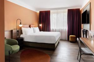 pokój hotelowy z dużym łóżkiem i biurkiem w obiekcie Mayburg Salzburg, a Tribute Portfolio Hotel w mieście Salzburg