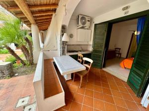 a patio with a table and a kitchen with a door at JERA Holiday Collection VULCANO UNO - Garden View in Vulcano
