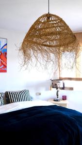 ein Schlafzimmer mit einem Bett und einer Hängeleuchte in der Unterkunft Authentic Andalusian Boho Villa - Pool - Garden-BBQ- 7 Guests in Benalmádena