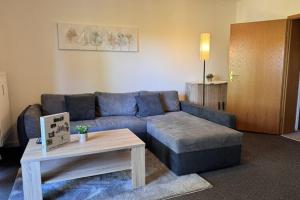 a living room with a blue couch and a coffee table at Geräumige Wohnung in Altenau mit Terrasse in Lissendorf