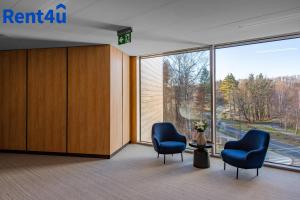 two blue chairs in a room with a large window at Nad Zatoką Aparthotel Deluxe by Rent4You in Olsztyn +64 photos