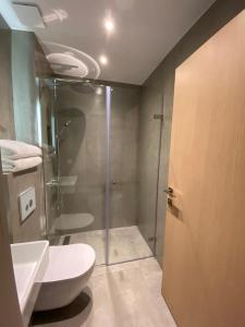a bathroom with a shower and a toilet and a glass door at Villa Eleni Greece - wonderful sea view studios in Nea Roda