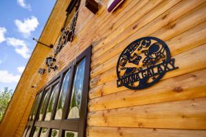 a sign on the side of a wooden building at Cabana Galaxy A Frame by Cabanele Galaxy in Cucuteni