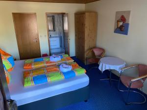 a bedroom with a bed with two chairs and a table at Motel Zur Festwiese in Gierstädt +36 photos