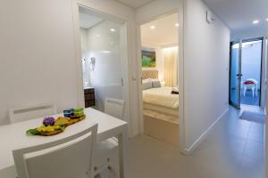 a white bathroom with a sink and a bedroom at GuestReady - Passal Guesthouse in Ponta Delgada