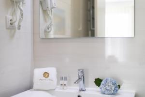 a bathroom sink with a mirror and a towel at GuestReady - Passal Guesthouse in Ponta Delgada +10 photos
