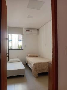 a small room with two beds and a window at Casa Sagrada 282 in Fortaleza +13 photos
