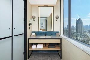 un bagno con lavandino e specchio di Four Points by Sheraton Kunming Dongfeng Square a Kunming