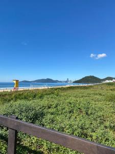 a bench on a beach with the ocean in the background at Container House Praia Brava Brava Beach in Itajaí