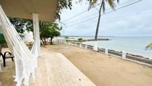 a porch with a hammock overlooking the beach at Cabaña Costa de Oro in San Antero