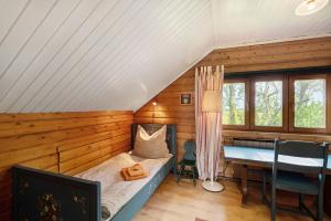 a bedroom with a bed and a table in a room at Ferienhaus Schleiblick Gunneby in Ulsnis