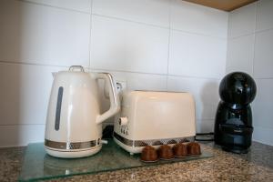 eine Kaffeemaschine und ein Toaster auf der Theke in der Unterkunft GuestReady - Salomão Luminous Apartment in Senhora da Piedade