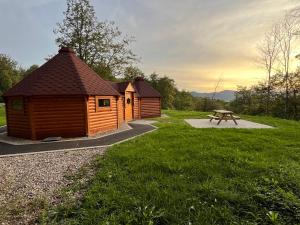 a wooden cabin with a picnic table in a park at Les chaumines in Albé +19 photos