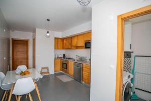 eine Küche mit Holzschränken und einem Tisch und Stühlen in der Unterkunft GuestReady - Salomão Luminous Apartment in Senhora da Piedade