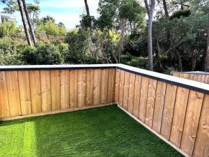 a wooden fence with a yard of green grass at Maison bord de mer Anglet in Anglet +3 photos