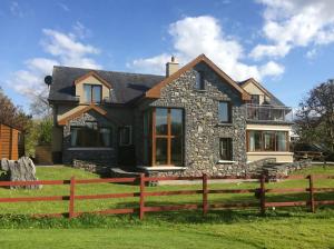 a house with a fence in front of it at Golf Course View in Kenmare