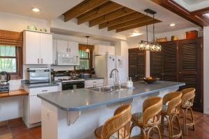 a kitchen with a large counter with chairs in it at Cielo Vista Villa 3 BDRM Sleeps 6 Heavenly View in Cruz Bay