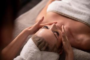 a woman laying in a towel with her hands on her face at Ad Maiora Luxury Glamping private Spa in Faedis