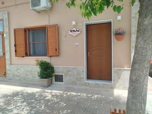 a house with a brown door and a window at CAMARDA HOME in Bernalda