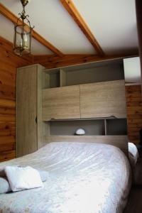 Schlafzimmer mit einem Bett mit einem großen Kopfteil in der Unterkunft Le Chalet in Montfroc