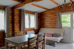 a dining room with a table and a couch at Le Chalet in Montfroc