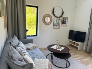 a living room with a couch and a table at Nybyggd gästlägenhet med sovloft in Falkenberg