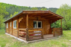 eine Holzhütte mit Veranda auf einem Feld in der Unterkunft Le Chalet in Montfroc