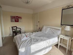 a bedroom with a white bed and a chair at Spacious 4-Bedrooms Solihull Home ideal for Contractors in Solihull