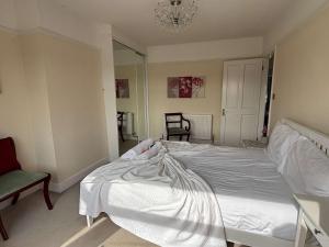 a bedroom with a white bed and a chair at Spacious 4-Bedrooms Solihull Home ideal for Contractors in Solihull +31 photos