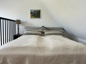 a bed in a white room with a bed sidx sidx sidx at Nybyggd gästlägenhet med sovloft in Falkenberg